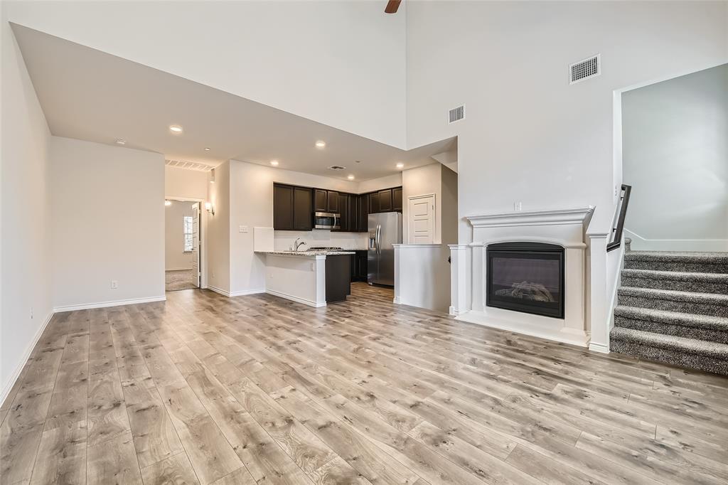 2407 Siskiyou Street Lewisville, TX 75056 - Photo 6 of 31 a view of kitchen and empty room with wooden floor
