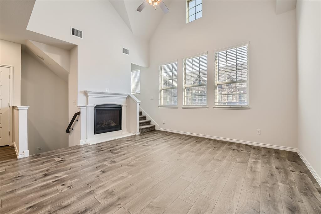 2407 Siskiyou Street Lewisville, TX 75056 - Photo 7 of 31 an empty room with windows a fireplace and wooden floor