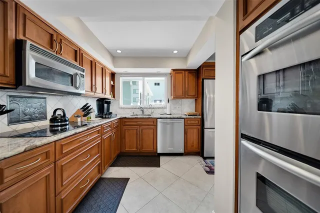 a kitchen with stainless steel appliances granite countertop a refrigerator and a stove top oven