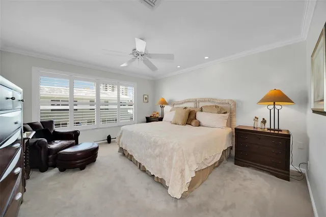 a spacious bedroom with a bed a couch and large window