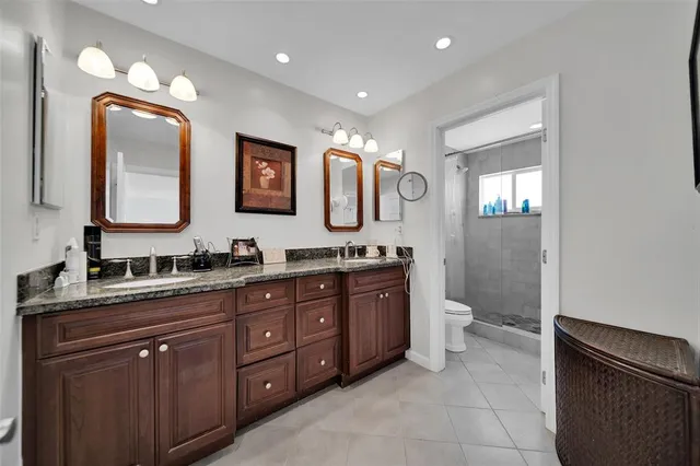 a spacious bathroom with a granite countertop sink mirror and toilet