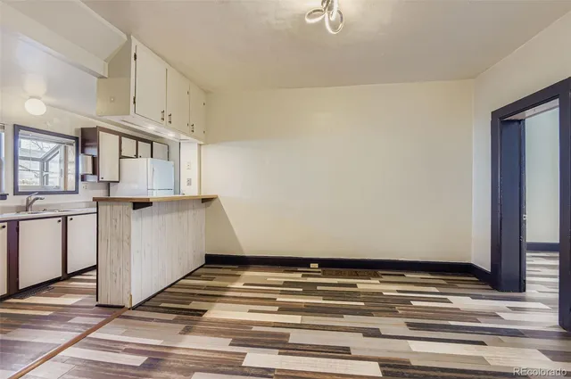 a view of a kitchen with wooden floor and cabinets
