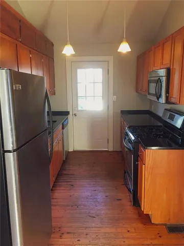 a kitchen with granite countertop a refrigerator and a stove