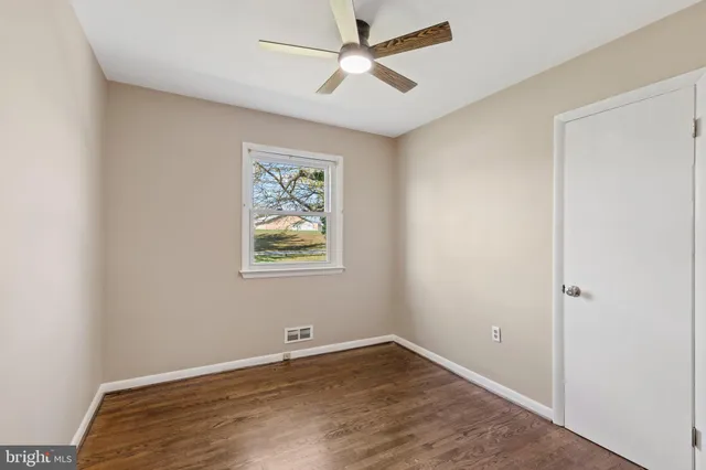 an empty room with a window and a ceiling fan