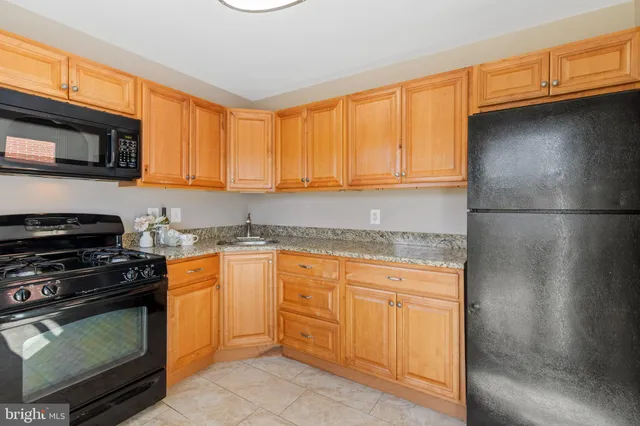 a kitchen with granite countertop a sink stainless steel appliances and cabinets