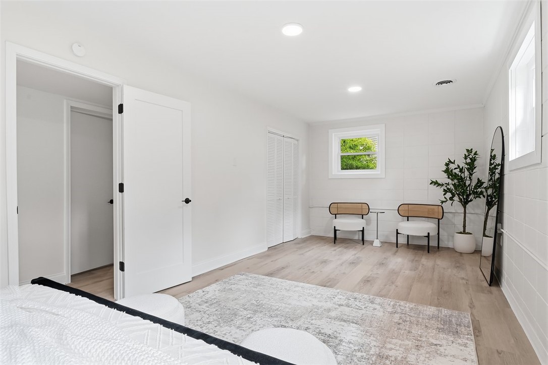 107 Edwards Mill Road Taylors, SC 29687 - Photo 20 of 34 A well-lit bedroom features pristine white walls and elegant wood flooring, creating a serene and modern retreat.