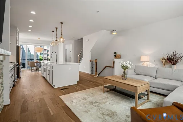 a kitchen with granite countertop a sink cabinets stainless steel appliances and dining table