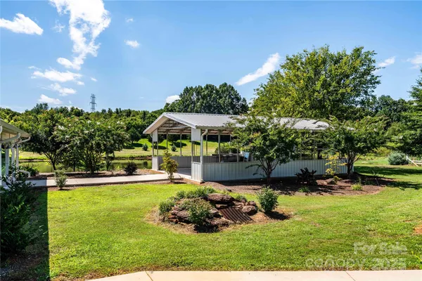 a view of a swimming pool with lawn chairs under an umbrella