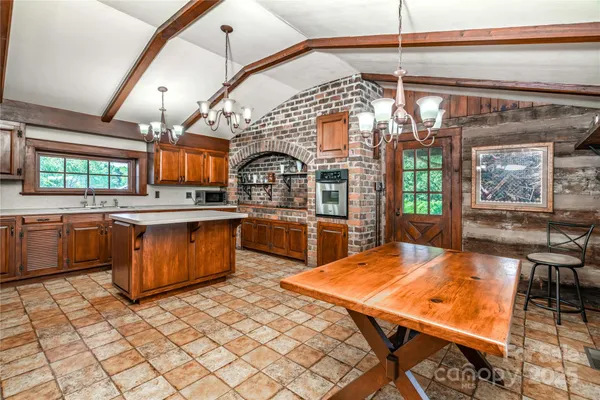 a living room with stainless steel appliances kitchen island granite countertop a stove a sink dishwasher and cabinets with wooden floor