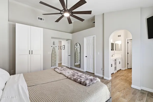 a bedroom with a large bed and a chandelier