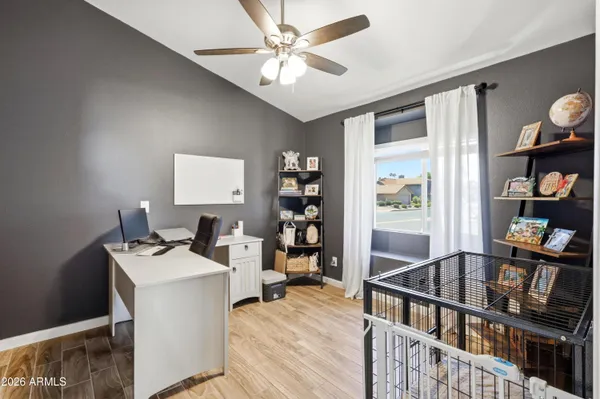 a room with furniture a ceiling fan and a book shelf