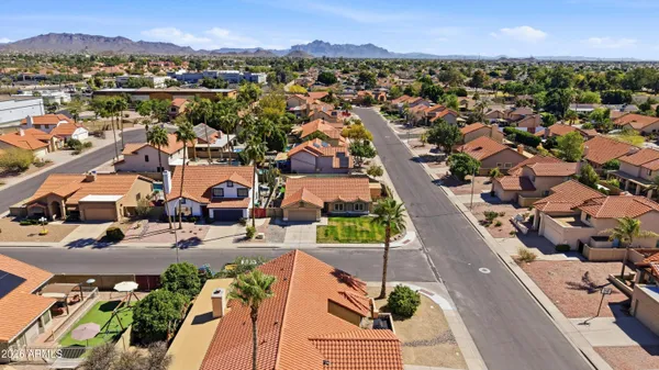 an aerial view of a city with lots of residential buildings and mountain view in back