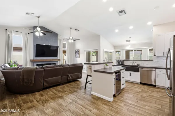 a living room with stainless steel appliances furniture and a flat screen tv