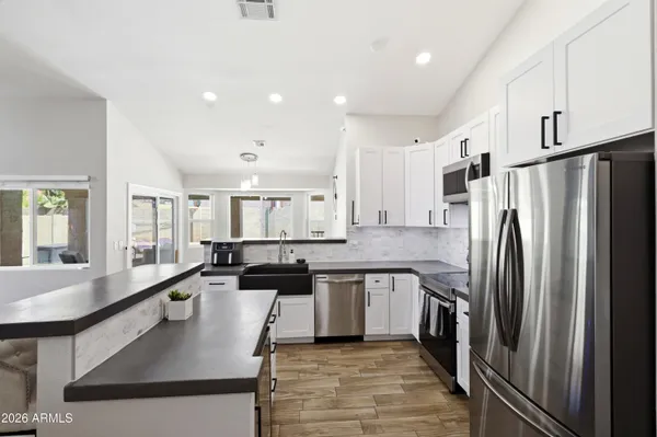 a large kitchen with stainless steel appliances lots of counter space and window