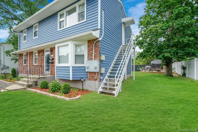 a front view of a house with a yard and green space
