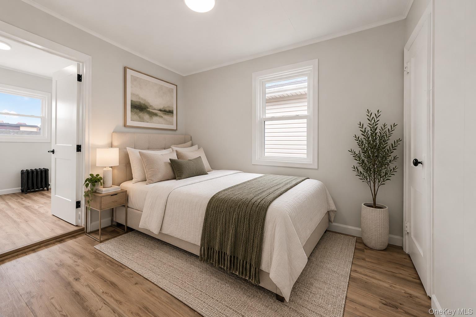 173-43 103rd Road Queens, NY 11433 - Photo 12 of 43 Light-colored walls complement wood-finish flooring, featuring a window with blinds and a solid interior door with dark hardware