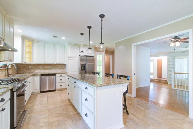 a kitchen with granite countertop a sink stove and cabinets