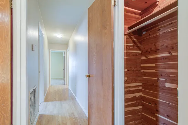 a view of a hallway with wooden floor and staircase