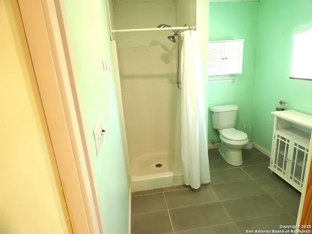 a bathroom with a toilet and a shower
