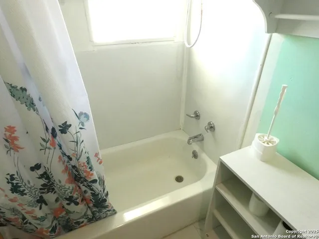a bathroom with a bathtub and shower