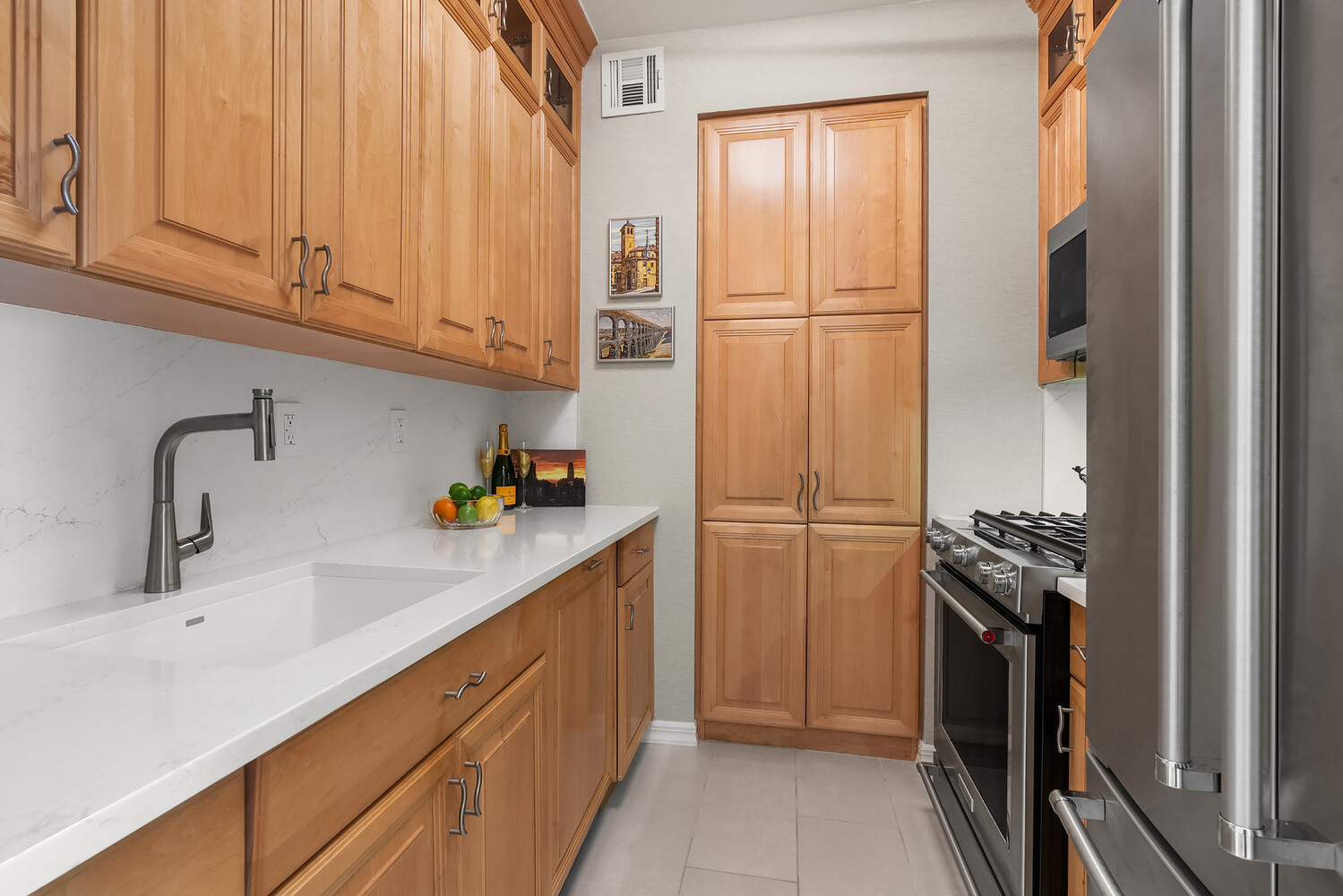 200 East 69th Street, Unit 16E Manhattan, NY 10021 - Photo 10 of 17 a kitchen with a refrigerator and a sink