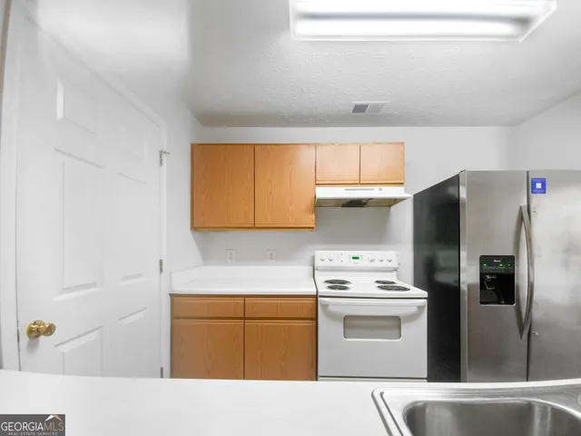 a kitchen with stainless steel appliances a refrigerator sink and cabinets
