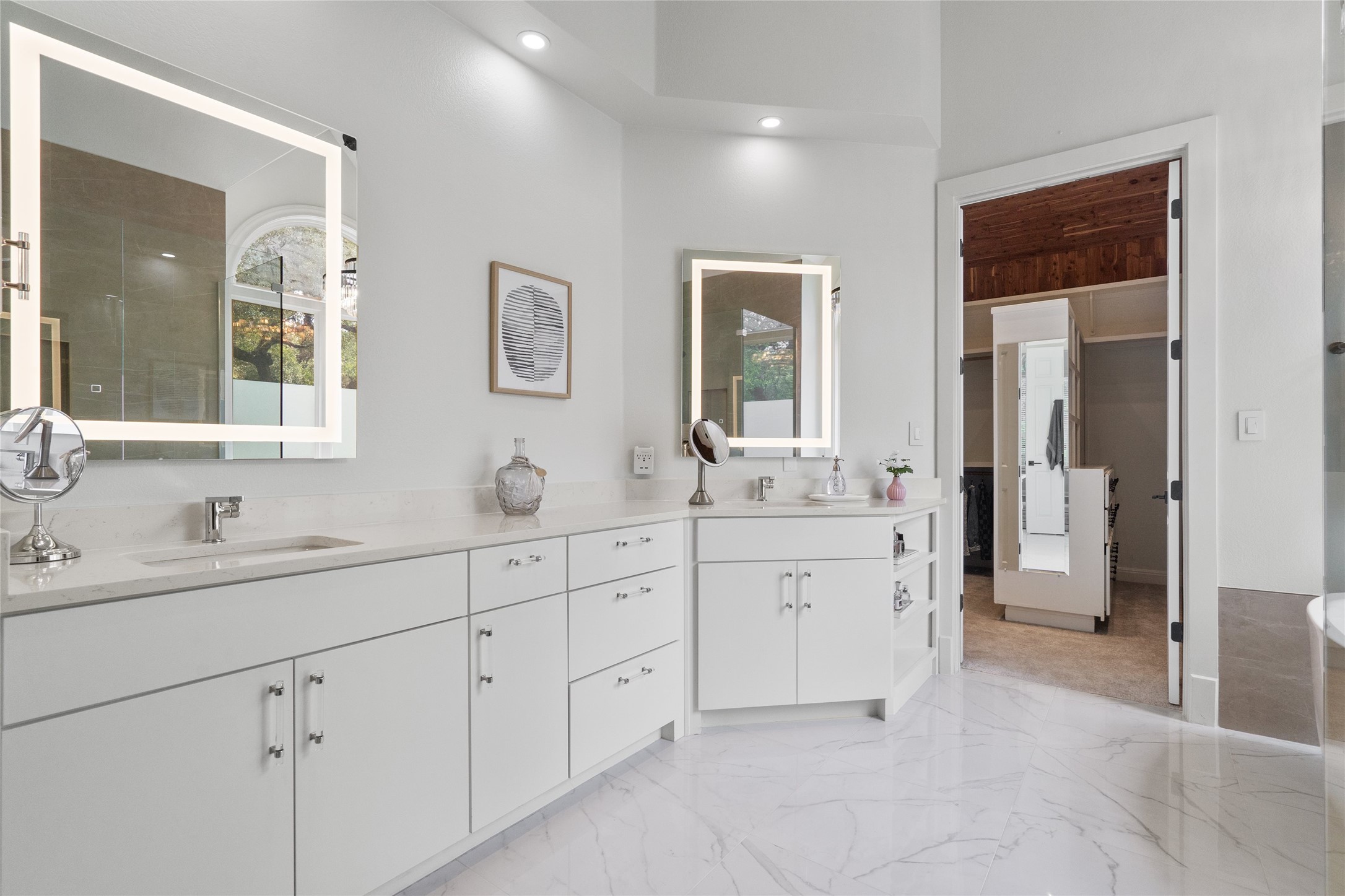 4313 Rio Robles Drive Austin, TX 78746 - Photo 22 of 40 Marble-look flooring and dual vanities define this modern primary bathroom.