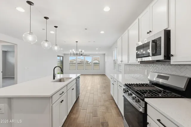 a kitchen with stainless steel appliances granite countertop a stove a sink and a microwave