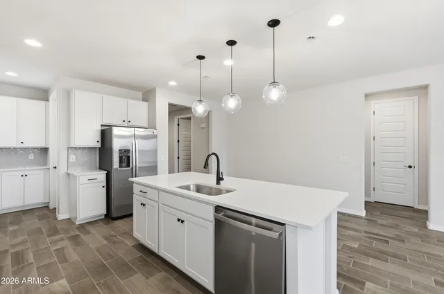 a kitchen with a sink a stove a refrigerator and cabinets