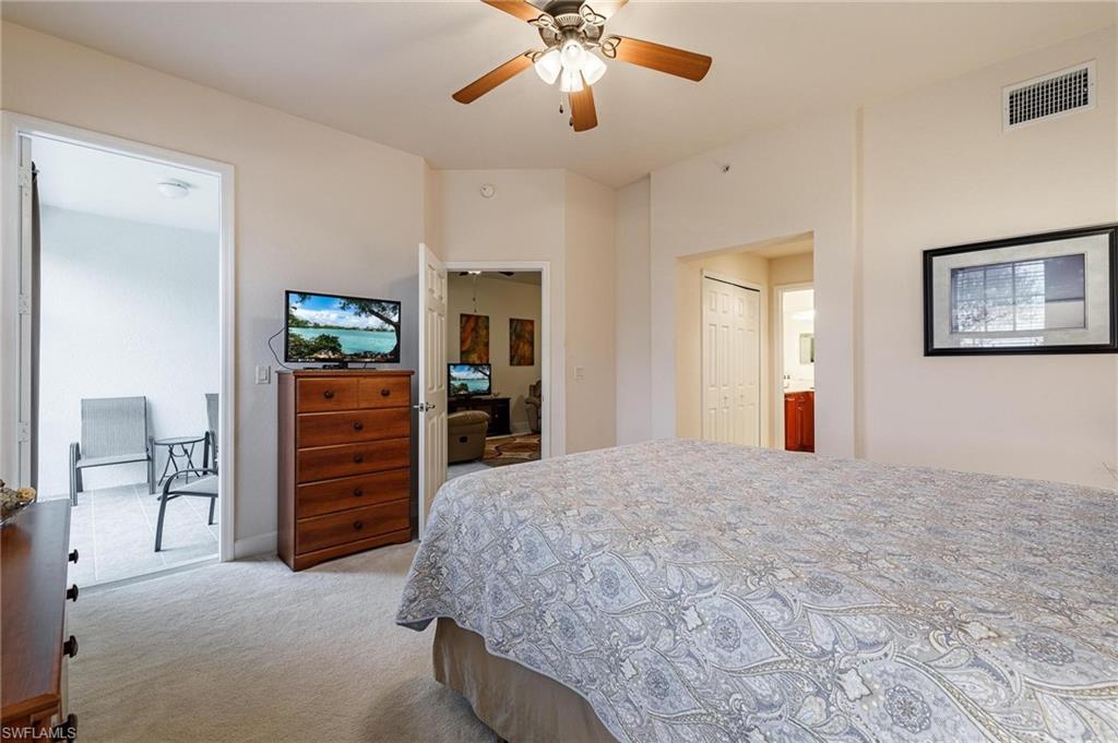 17298 Acapulco Road, Unit 512 Punta Gorda, FL 33955 - Photo 18 of 34 a spacious bedroom with a bed and a chandelier