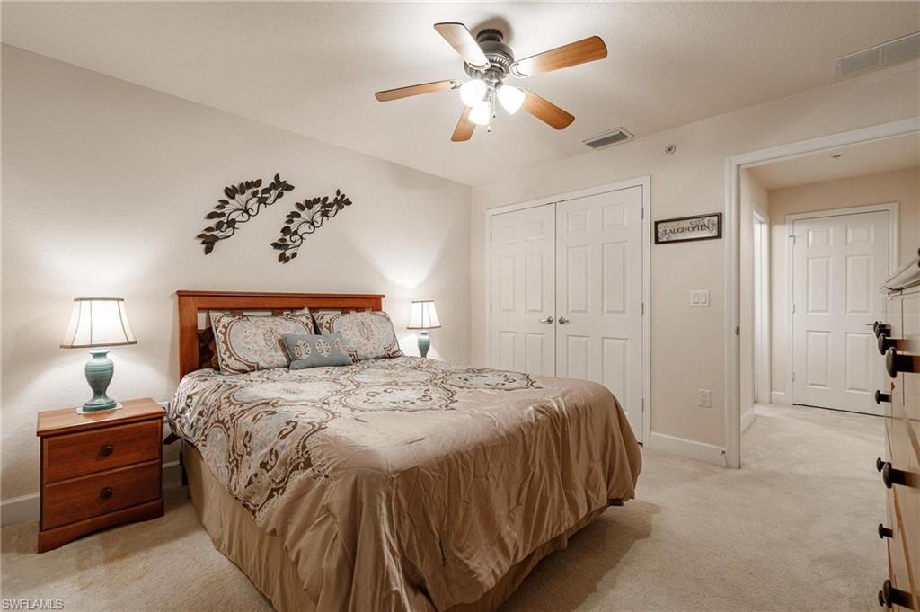 17298 Acapulco Road, Unit 512 Punta Gorda, FL 33955 - Photo 20 of 34 a spacious bedroom with a bed and a chandelier