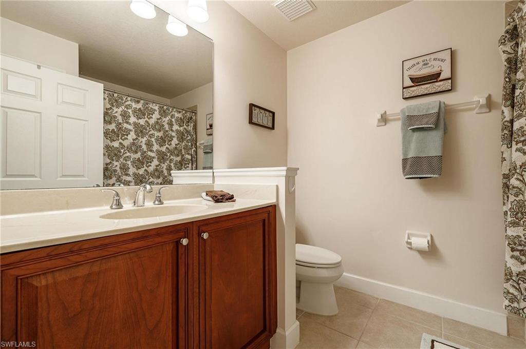 17298 Acapulco Road, Unit 512 Punta Gorda, FL 33955 - Photo 23 of 34 a bathroom with a granite countertop sink a toilet and a mirror