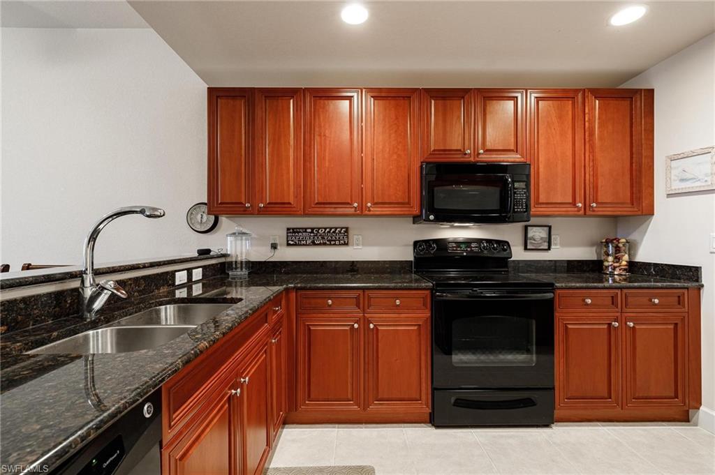 17298 Acapulco Road, Unit 512 Punta Gorda, FL 33955 - Photo 7 of 34 a kitchen with granite countertop a sink stainless steel appliances and cabinets
