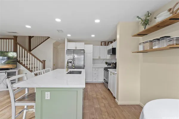 a kitchen with refrigerator cabinets and wooden floor