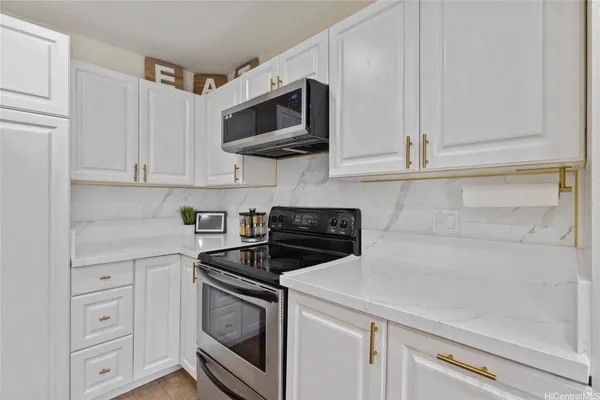 a kitchen with white cabinets and stainless steel appliances
