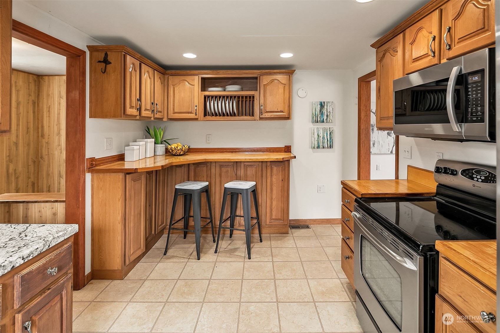39152 Southeast Delta Street Snoqualmie, WA 98065 - Photo 12 of 26 a kitchen with stainless steel appliances granite countertop a stove top oven a sink dishwasher and a refrigerator with wooden cabinets