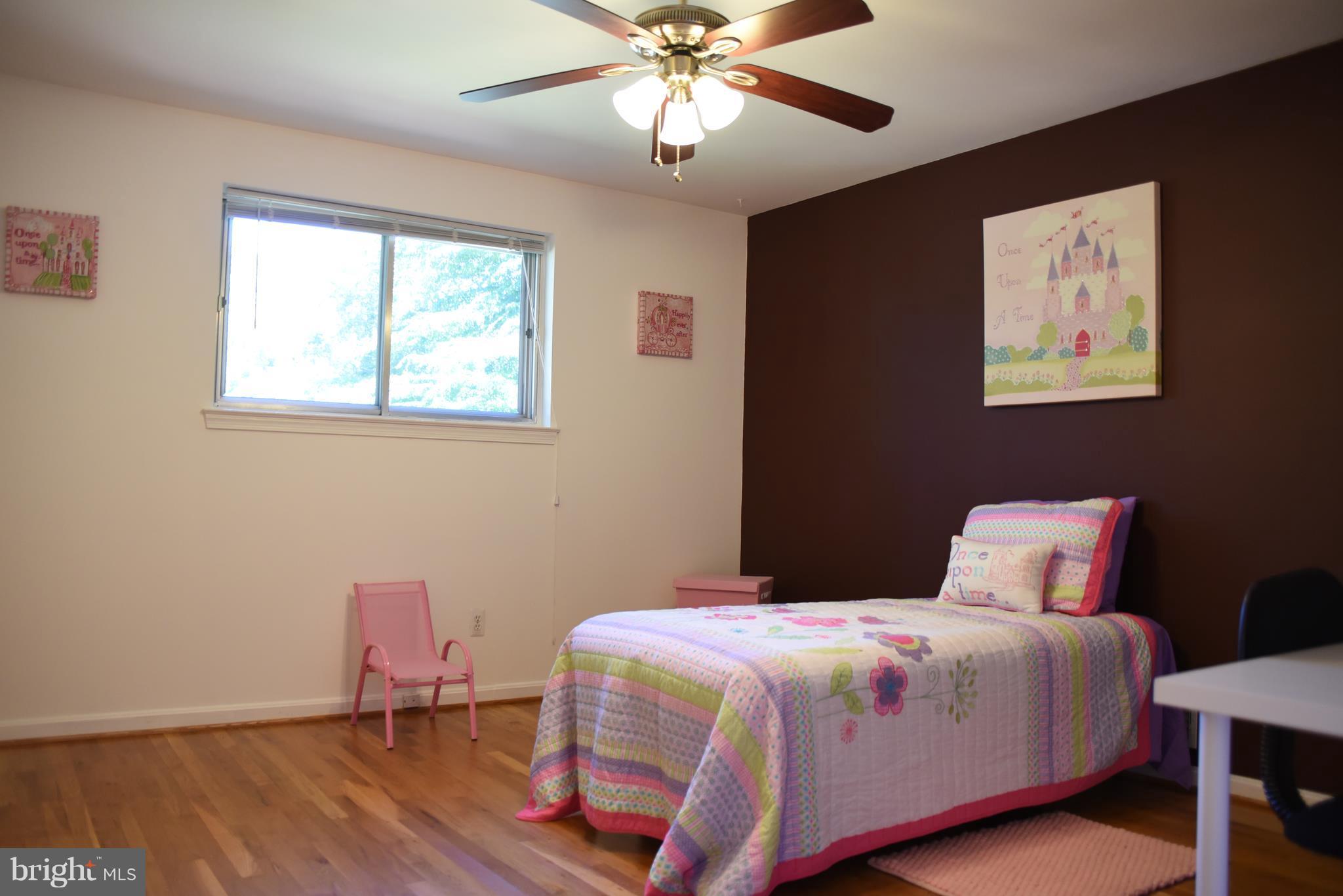 8911 Victoria Road Springfield, VA 22151 - Photo 13 of 22 a bedroom with a bed and a chandelier