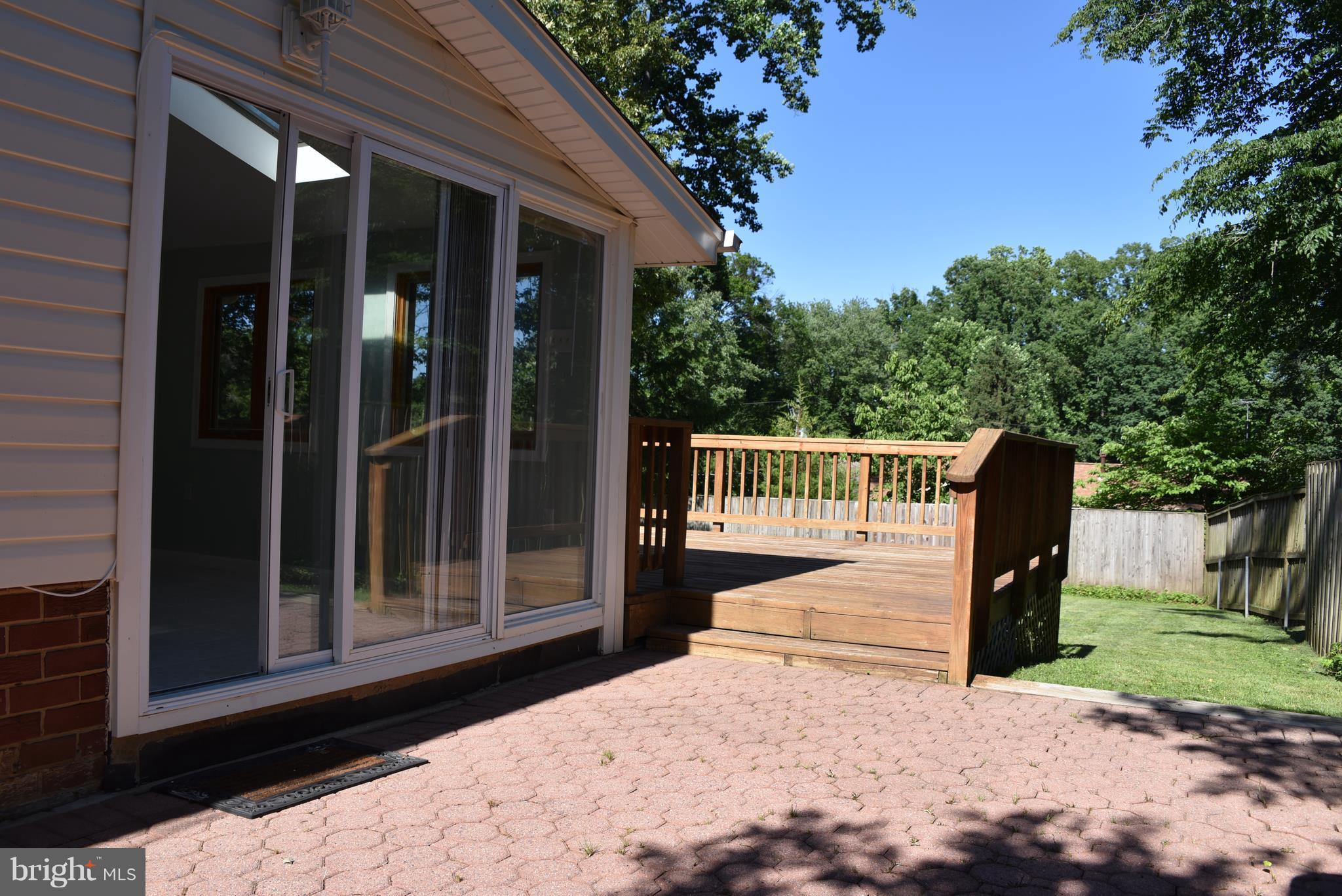 8911 Victoria Road Springfield, VA 22151 - Photo 19 of 22 a view of a deck with a floor to ceiling window and a yard