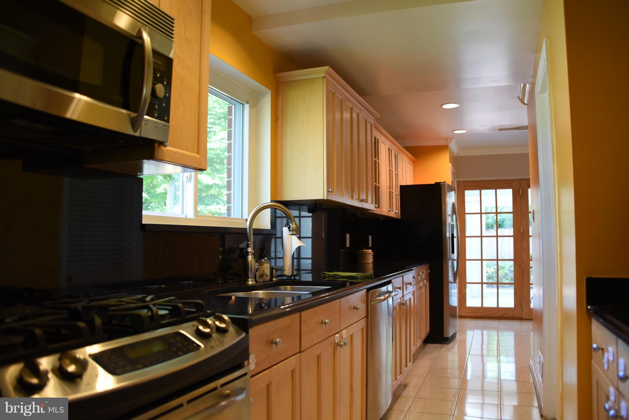 8911 Victoria Road Springfield, VA 22151 - Photo 9 of 22 a kitchen with a stove a sink and a window