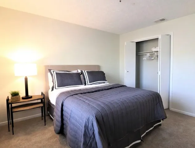 a bedroom with a bed and a night stand