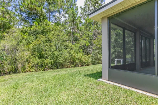 a view of a house with a yard and a large tree