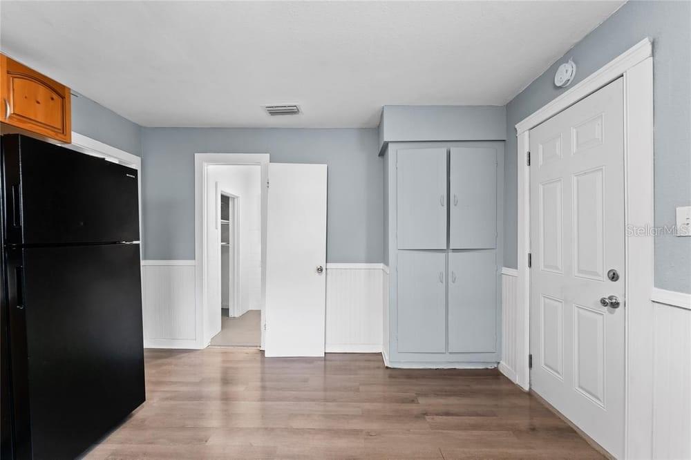 2320 West Walnut Street Tampa, FL 33607 - Photo 11 of 19 a view of an empty room with wooden floor and a cabinet