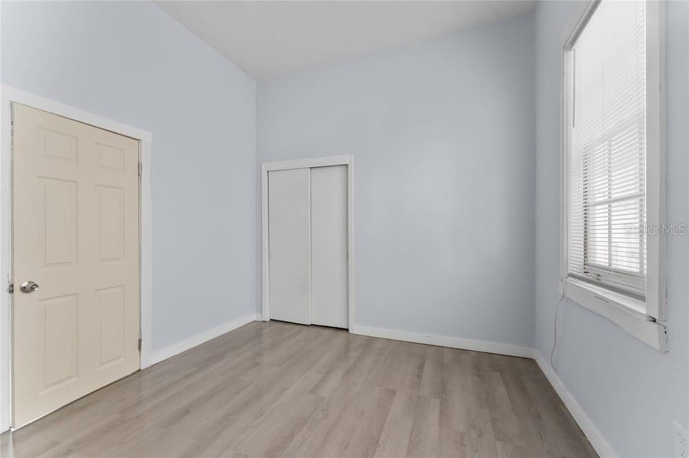 2320 West Walnut Street Tampa, FL 33607 - Photo 13 of 19 an empty room with wooden floor and windows