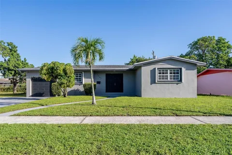 a front view of a house with a garden and yard