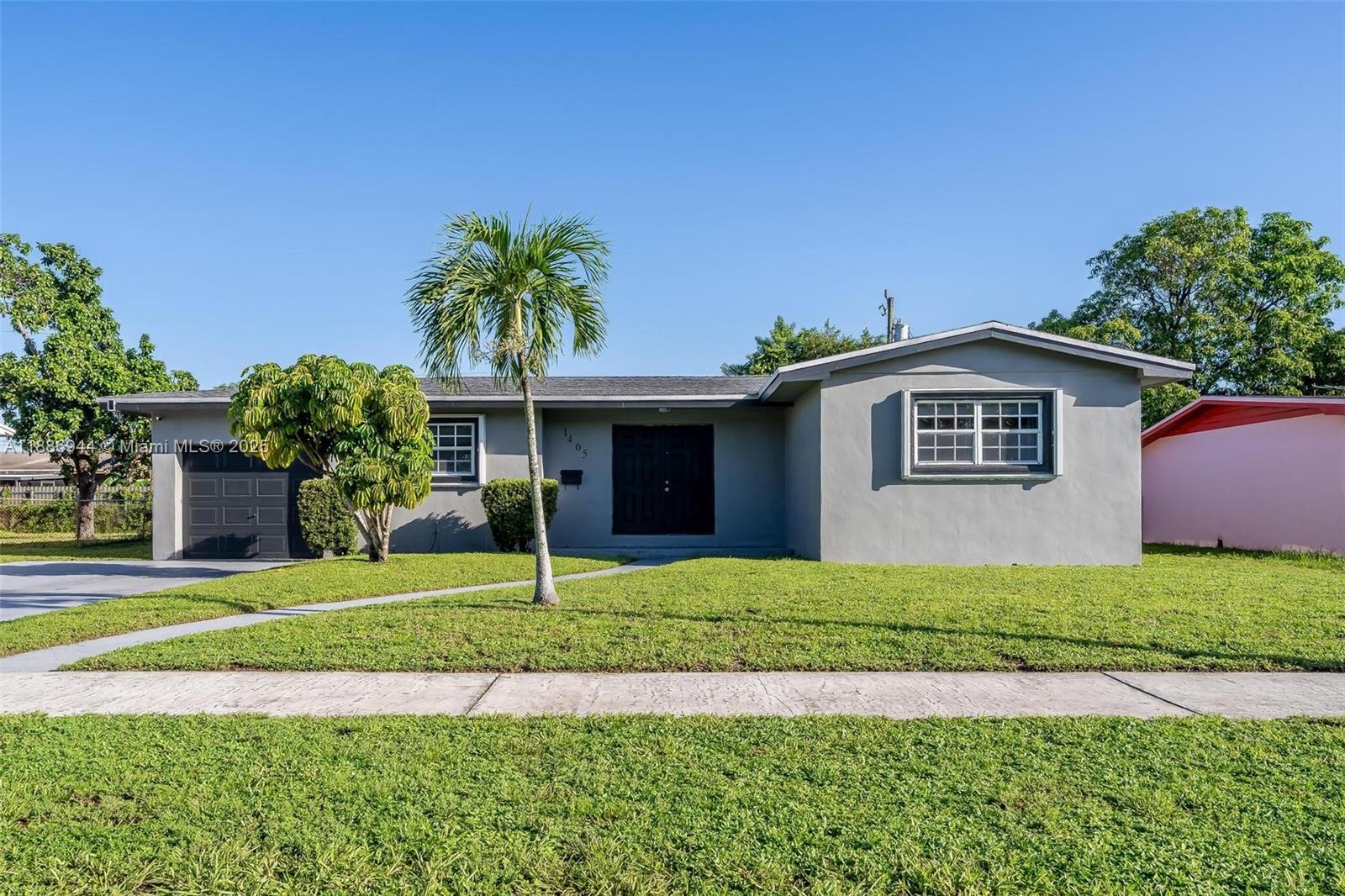 1465 Northwest 181st Street Miami Gardens, FL 33169 - Photo 15 of 15 a front view of a house with a garden and yard