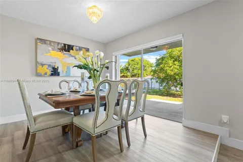 a view of a dining room with furniture a chandelier and wooden floor
