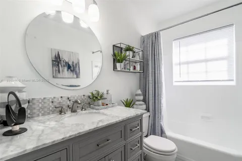 a bathroom with a granite countertop sink a toilet and a mirror