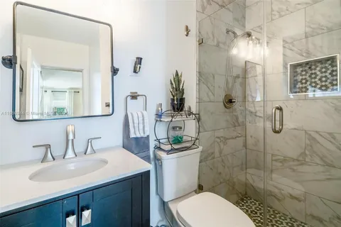 a bathroom with a sink toilet a mirror and shower