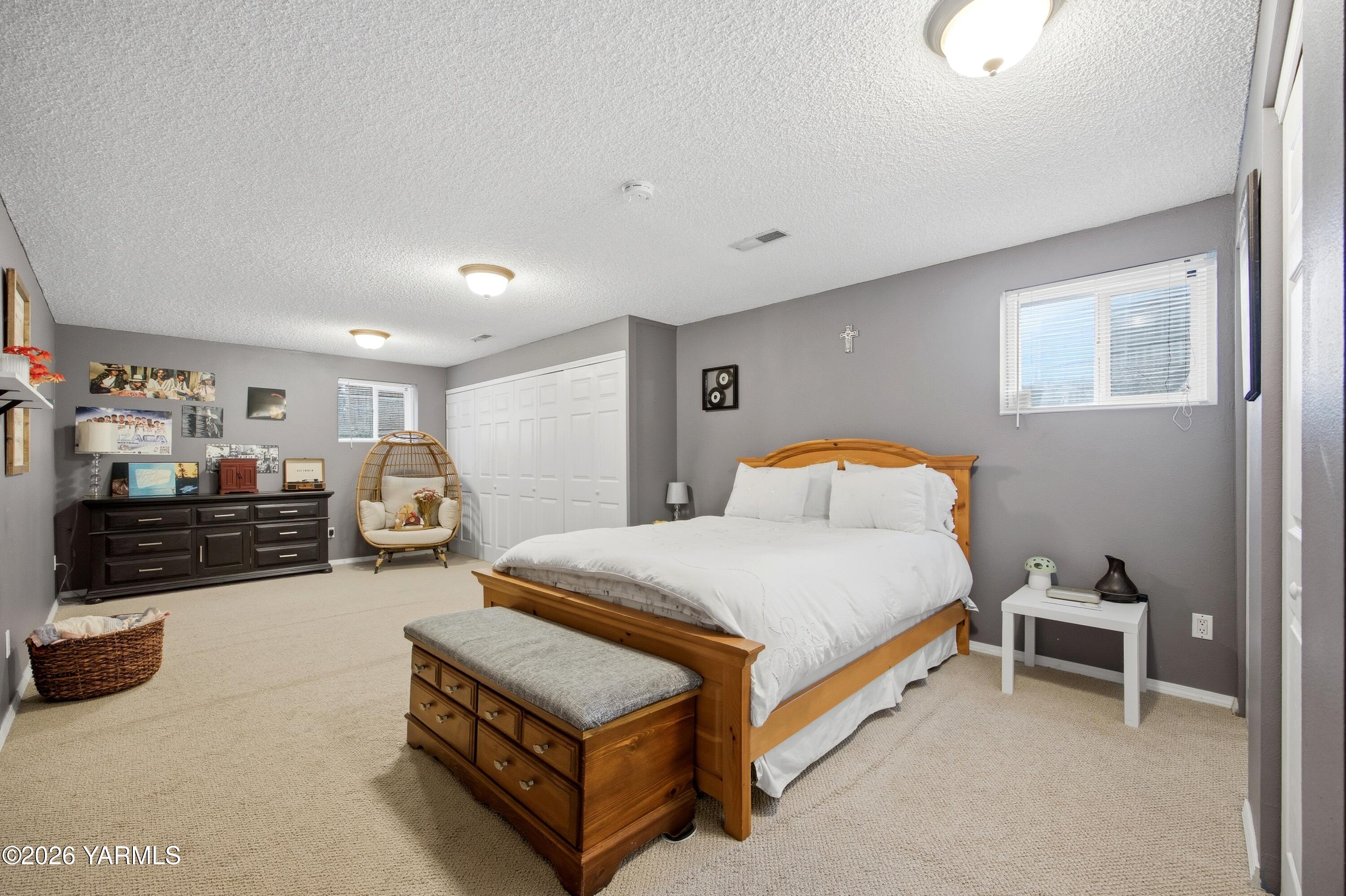 1681 Olmstead Road Grandview, WA 98930 - Photo 14 of 49 a spacious bedroom with a bed and a couch