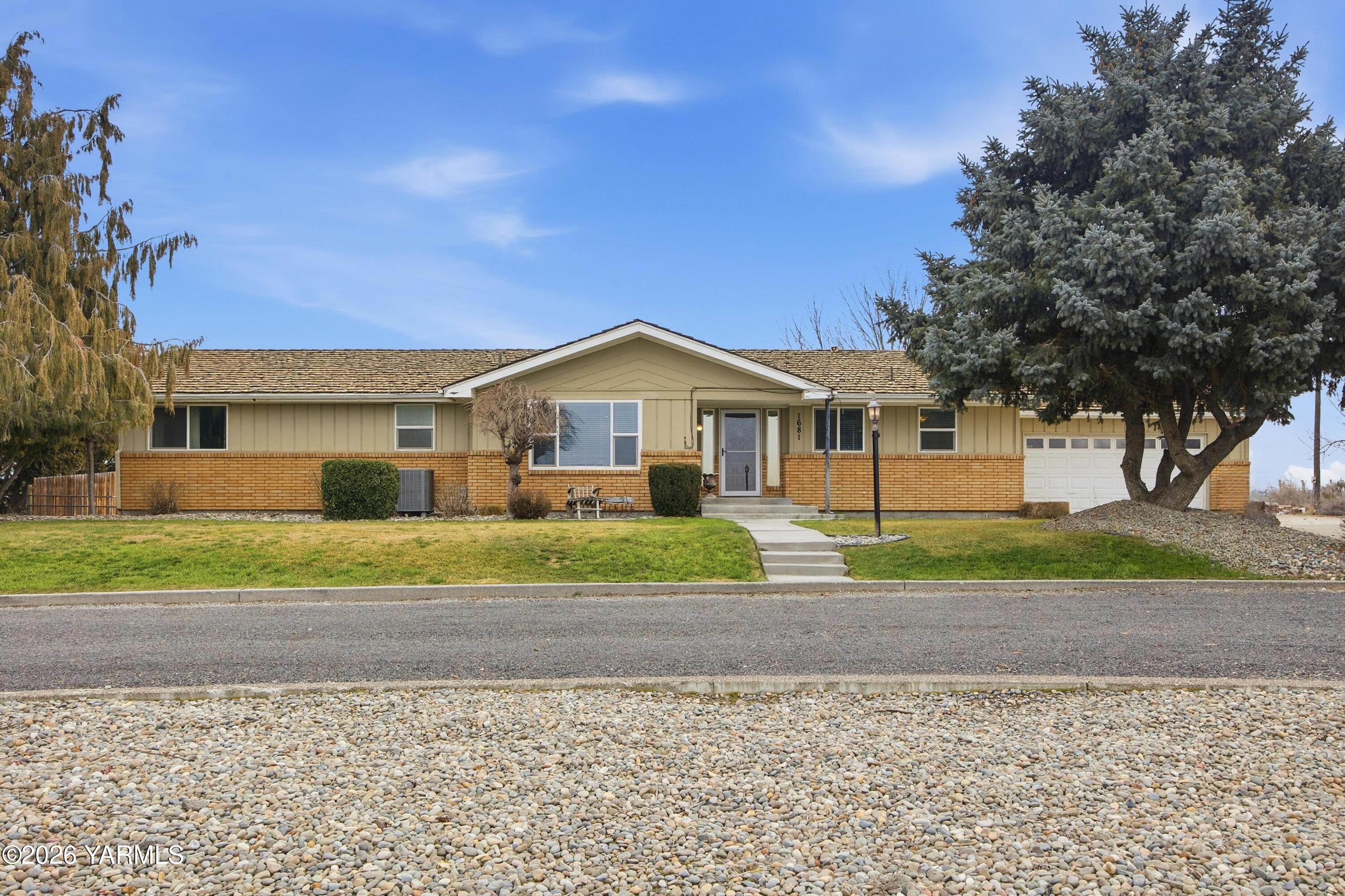 1681 Olmstead Road Grandview, WA 98930 - Photo 26 of 49 a front view of a house with a yard and garage